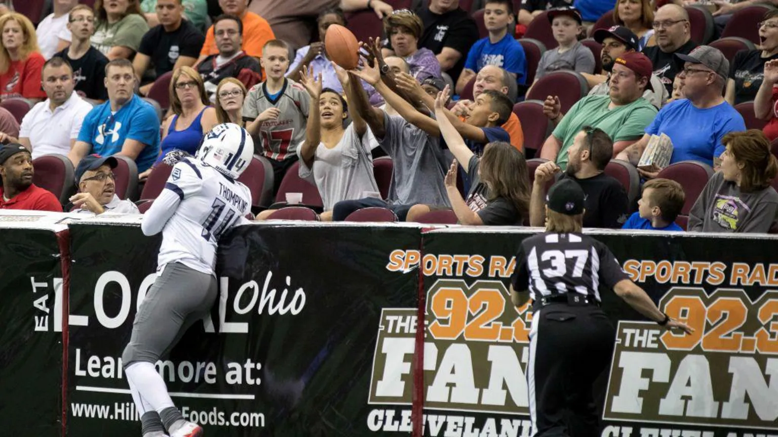  Fans reach for a football after it deflects into the stands during an indoor arena league American Football match