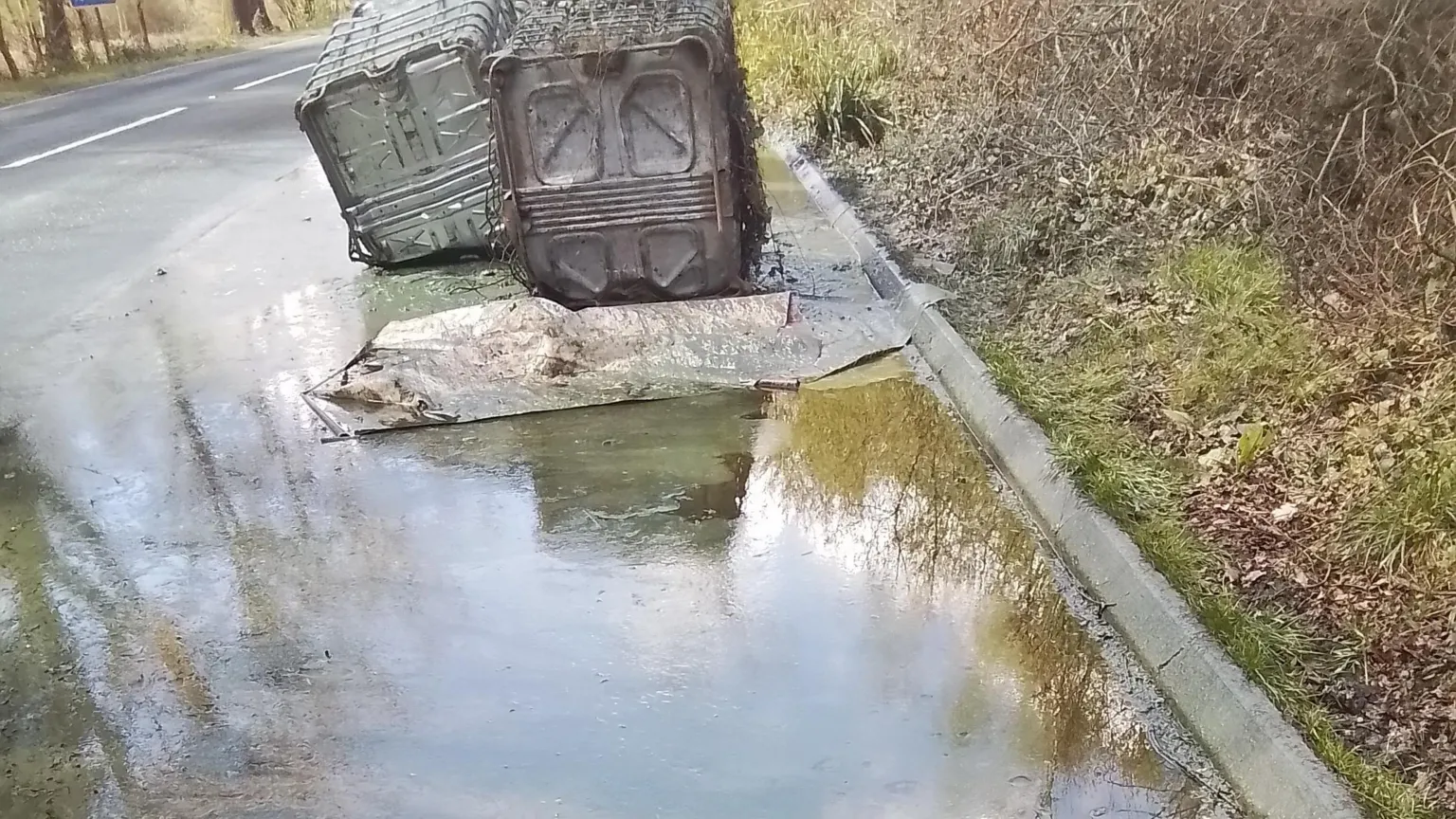 Dorset Council Two of the containers can be seen by the side of the road, next to a large pool of liquid.