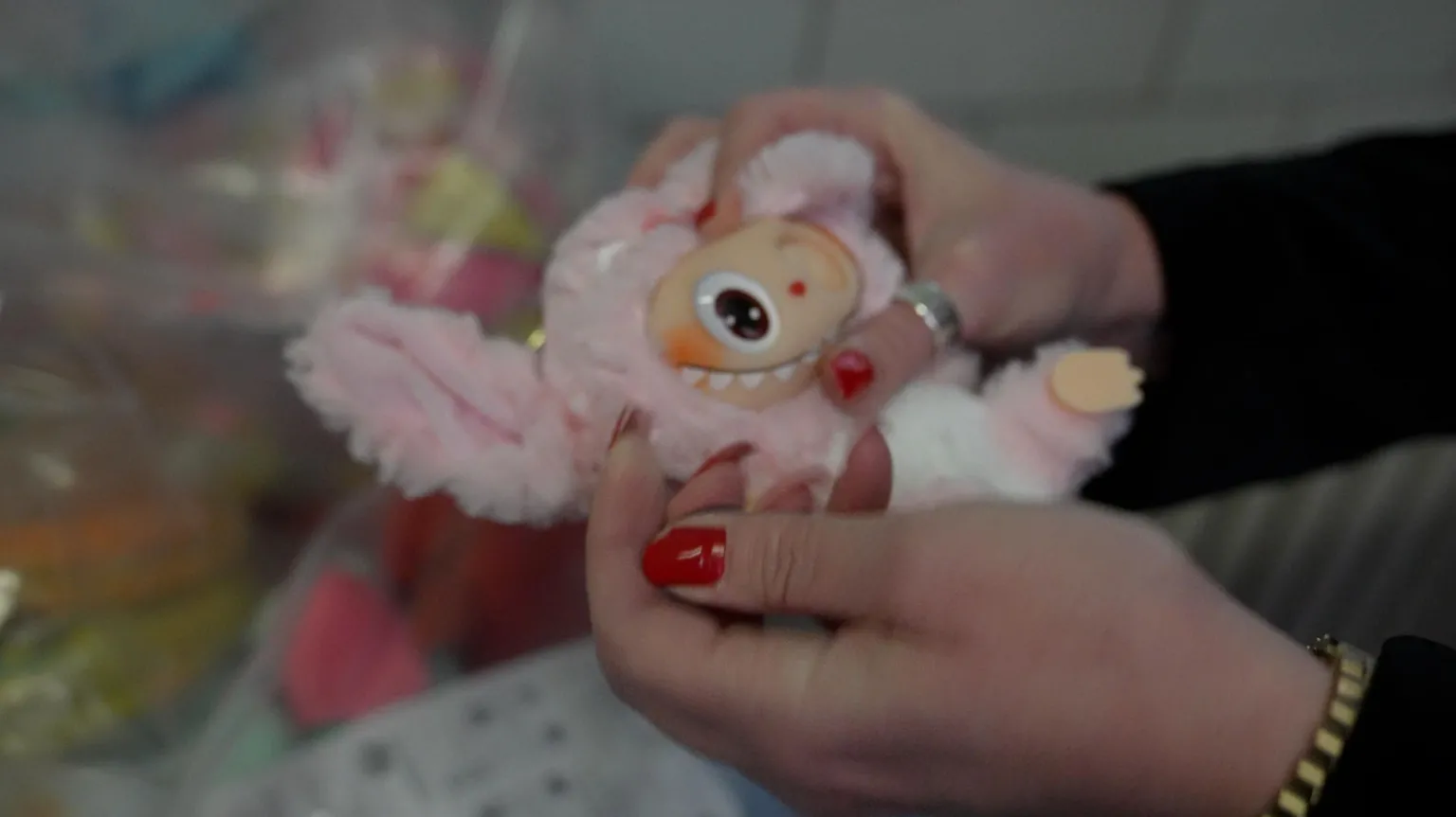 Counterfeit Labubu with an eye missing being held in hands