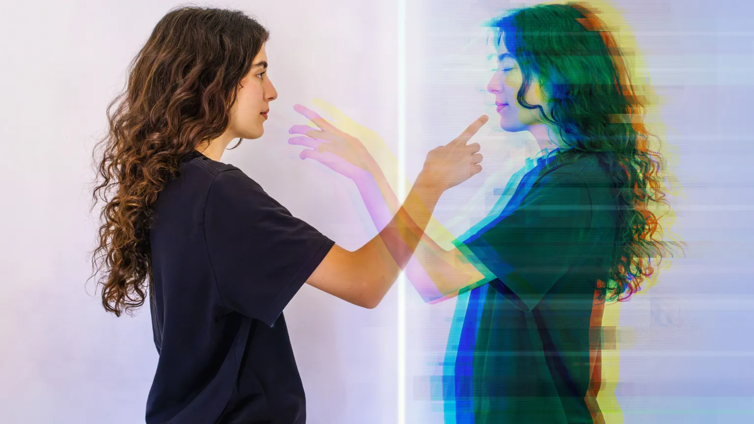  A lady points to a reflection of herself