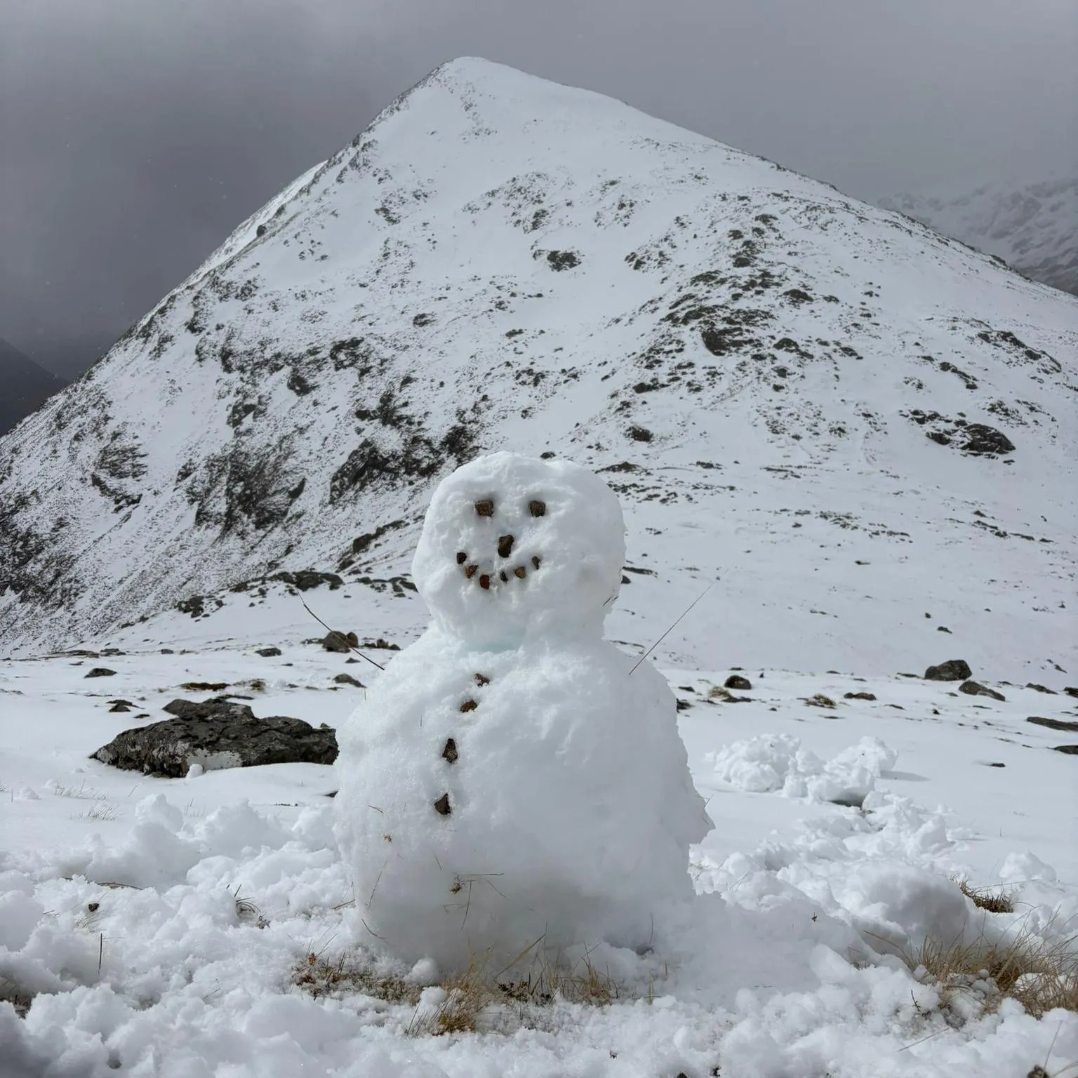 Gary Rushworth/Christopher Wallace A snowman at the foot of snow-capped hills.