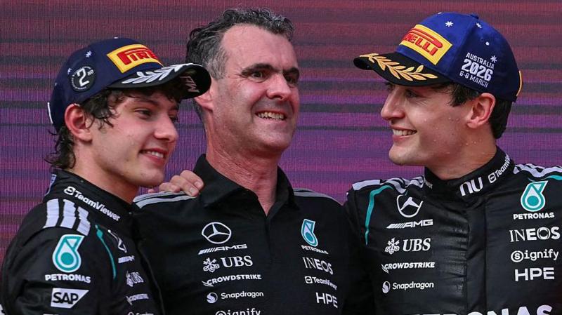 Kimi Antonelli and George Russell celebrate on the podium with Hywel Thomas, managing director of Mercedes AMG High Performance Powertrains, after F1's Australian Grand Prix in 2026