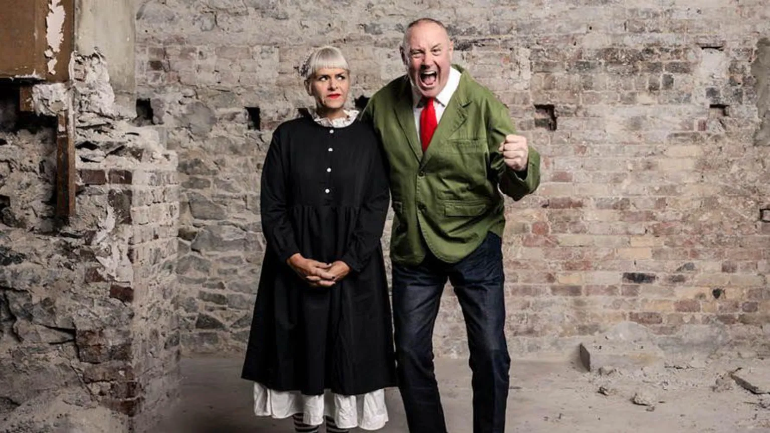 Patch Dolan Keith and Marj stood next to one another. Marj is looking a Keith out the corner of her eye. Keith has his fist clenched and mouth open with an excited expression.