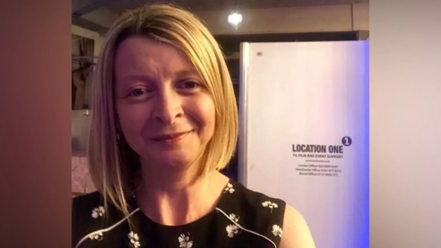 Jane Hawkes Jane Hawkes smiles at the camera. She has short blonde hair and wears a black sleeveless top with white flowers on it.