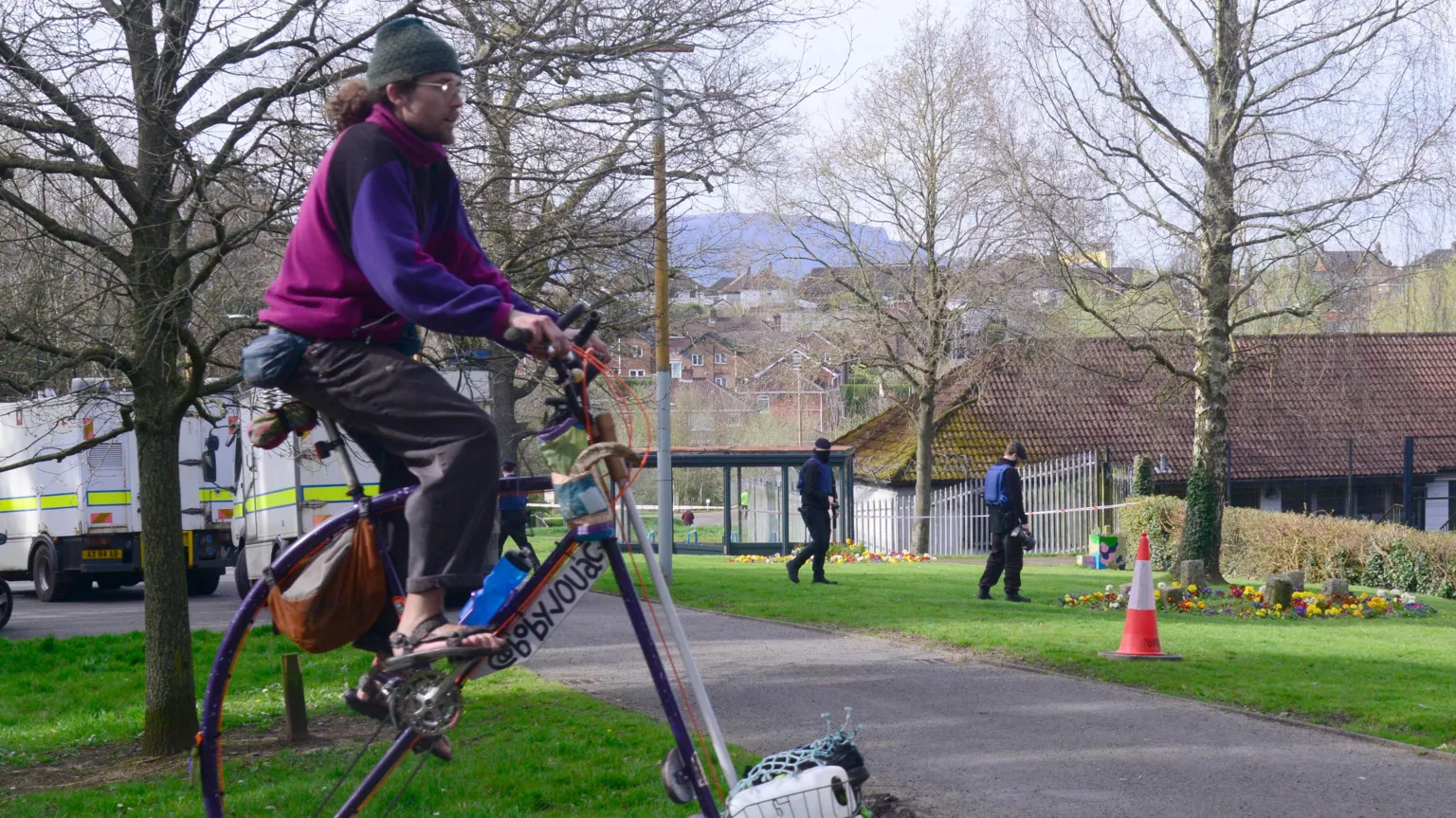 Pacemaker A man on a tall bike cycling through a park.