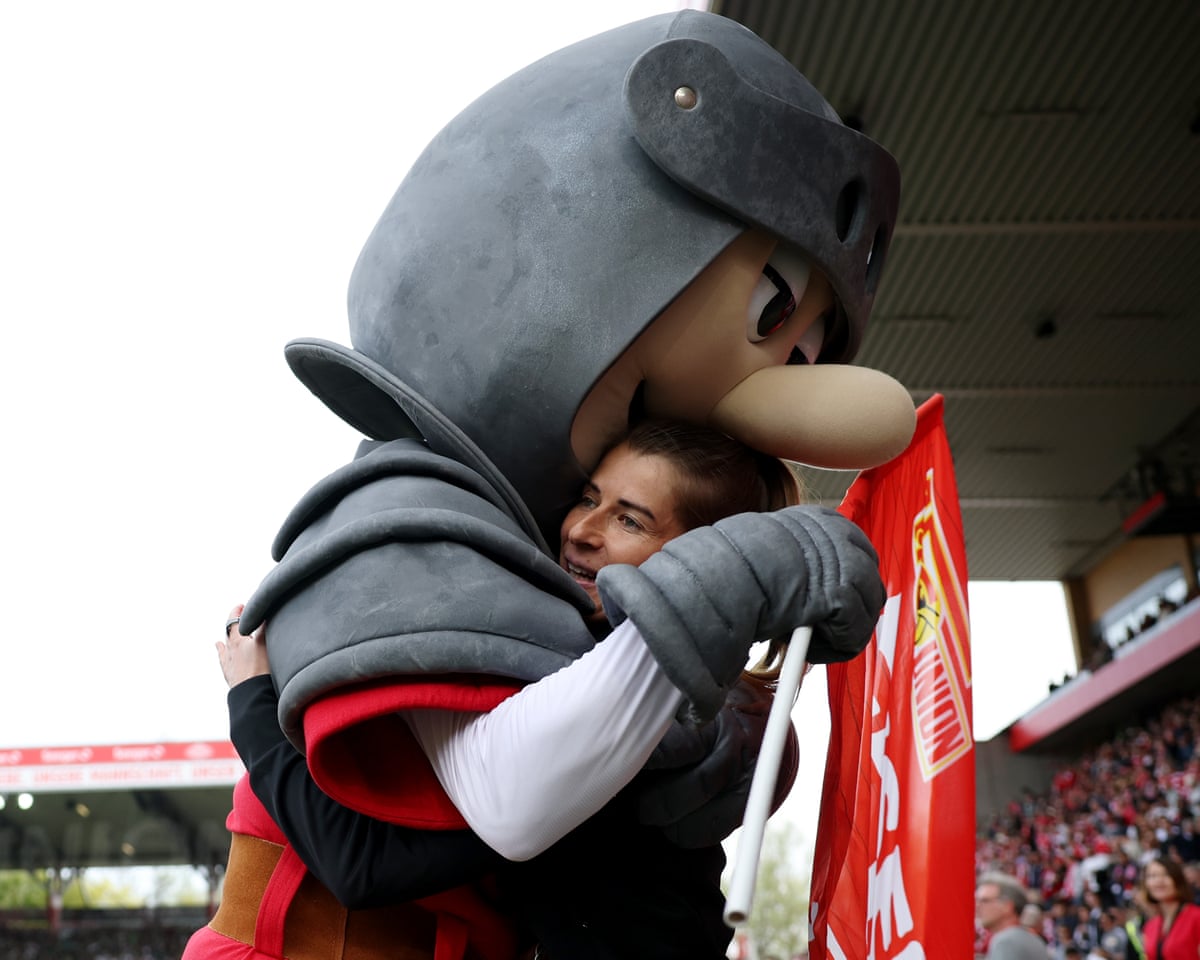 Marie-Louise Eta is hugged by club mascot Ritter Keule prior to the Bundesliga match.