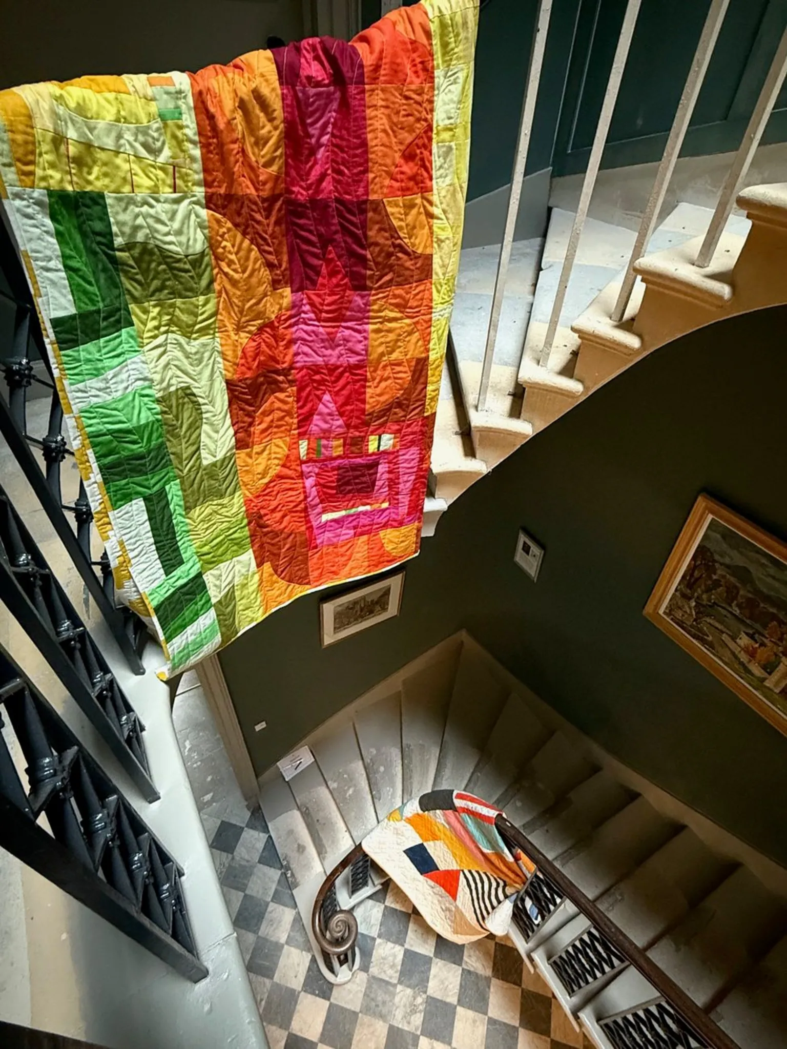 BMQG Two quilts draped over a swirling staircase