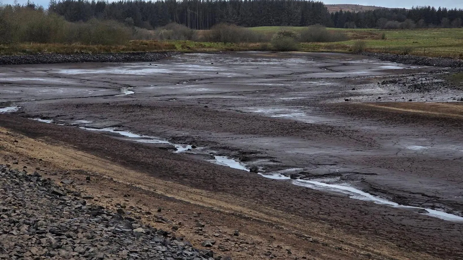 Wrexham Toad Patrols The empty reservoir with no water and muddy bottom