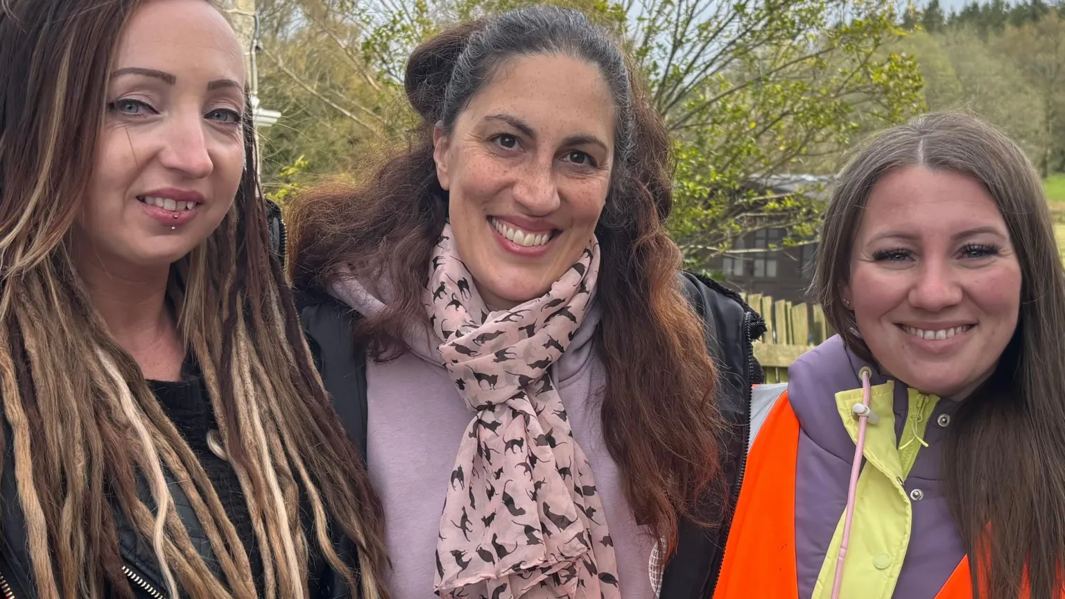 Becky Wiseman, Ella Thistleton and Teri Davies smiling at the camera in front of a woodland near the reservoir