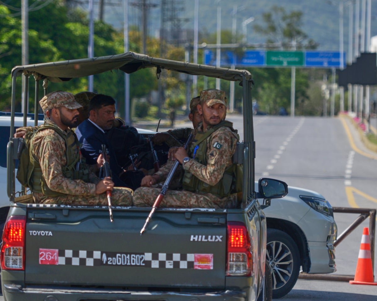 Security personnel in the back of a truck on a road in Islamabad
