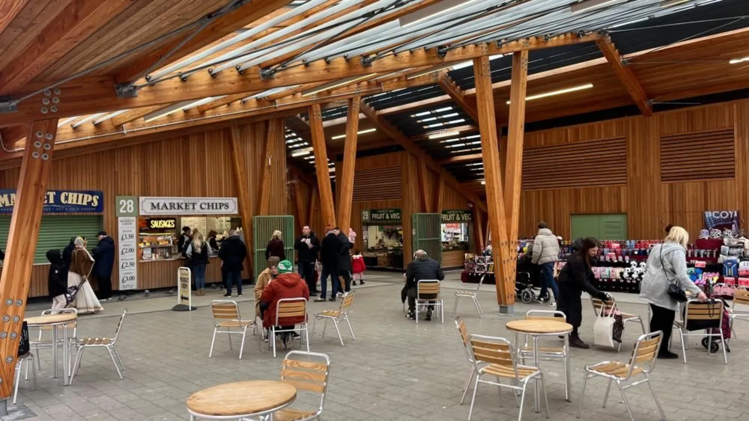 Andrew Turner/BBC Great Yarmouth's market hall, a wooden structure with zinc roof. In the foreground is seating and tables, with people milling about inside the market building. Stalls can be seen in the backdrop of the building.