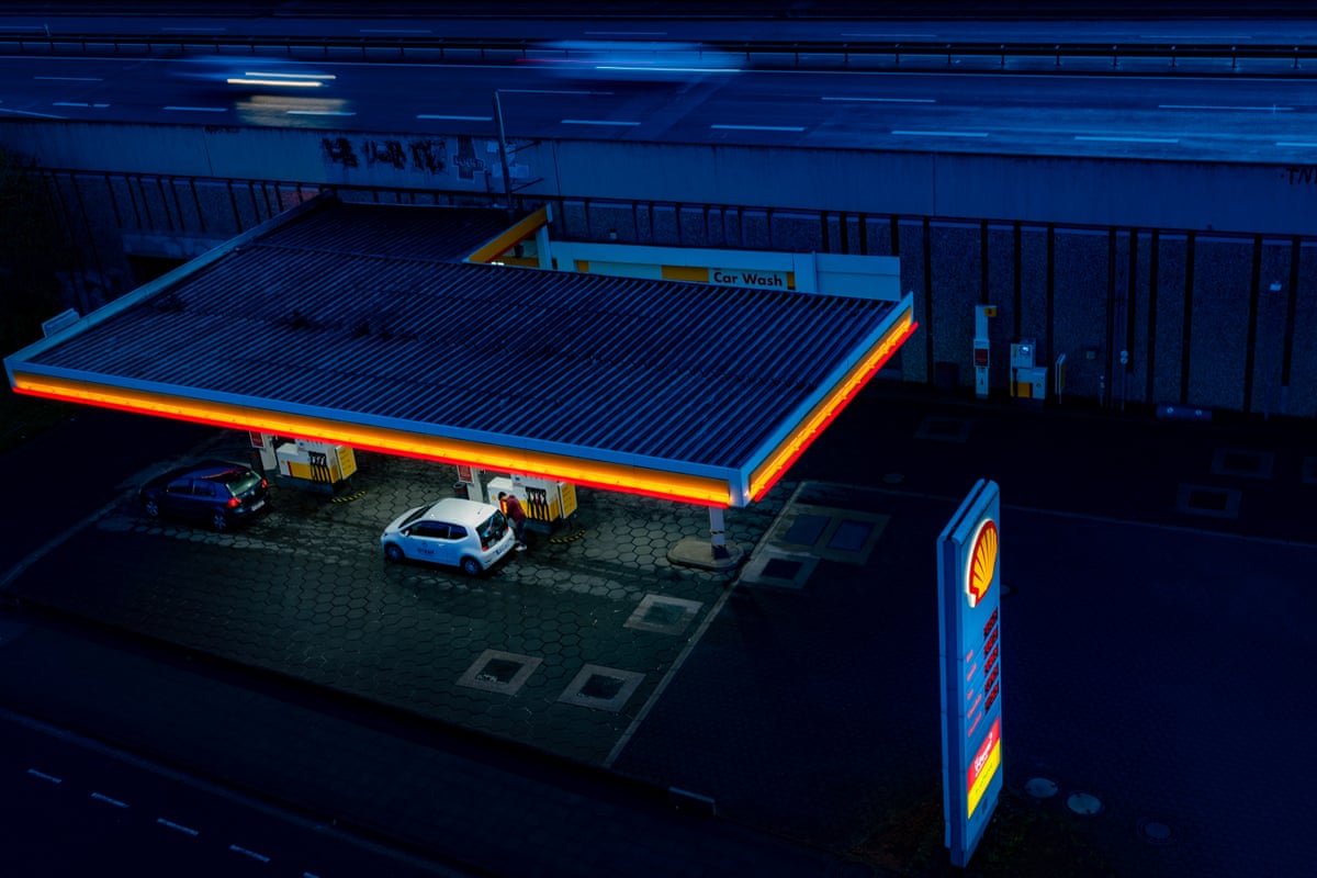 Customers fill up their tanks at a petrol station