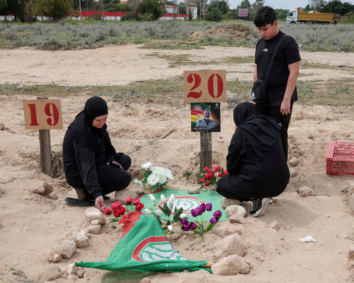A family mourns a relative killed in the war, at a temporary graveyard in Tyre, south Lebanon.