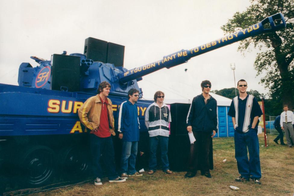 Aelodau'r Super Furry Animals o flaen tanc las ar faes yr Eisteddfod Genedlaethol yn Llandeilo yn 1996