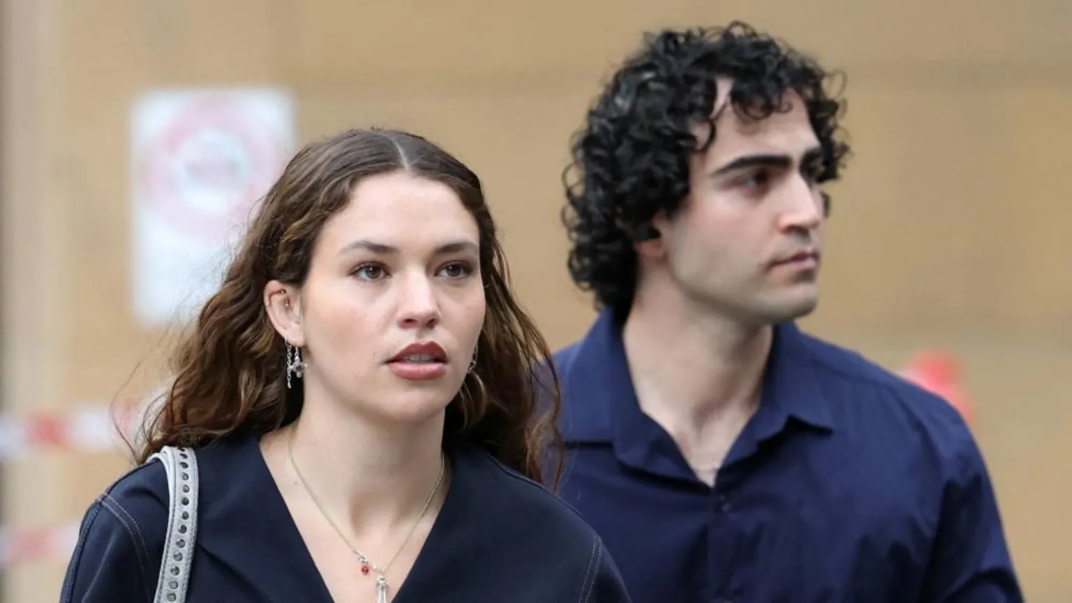  A young woman with long dark hair and earrings and a man with curly black hair 