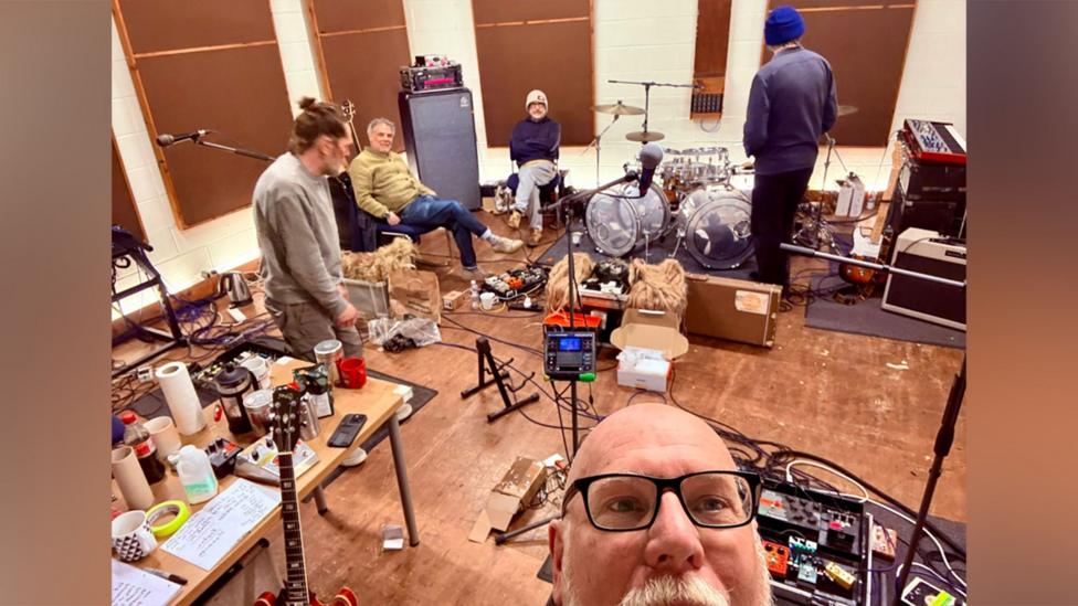 Dic Ben gyda'r Super Furries yn y cefndir