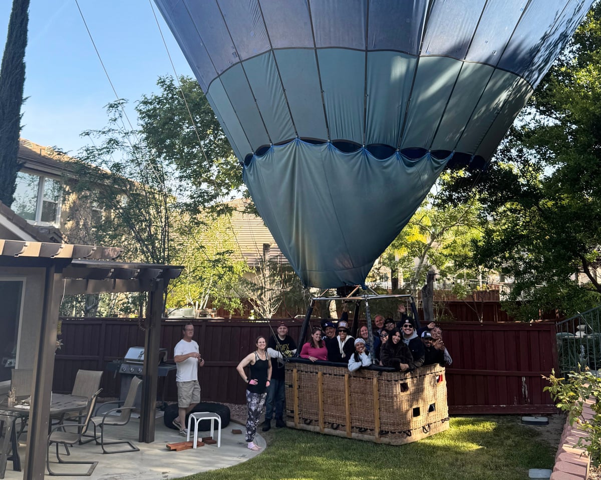 People riding a hot air balloon posing for a photo after making an emergency landing in Hunter Perrin's back yard on 18 April in Temecula, California.