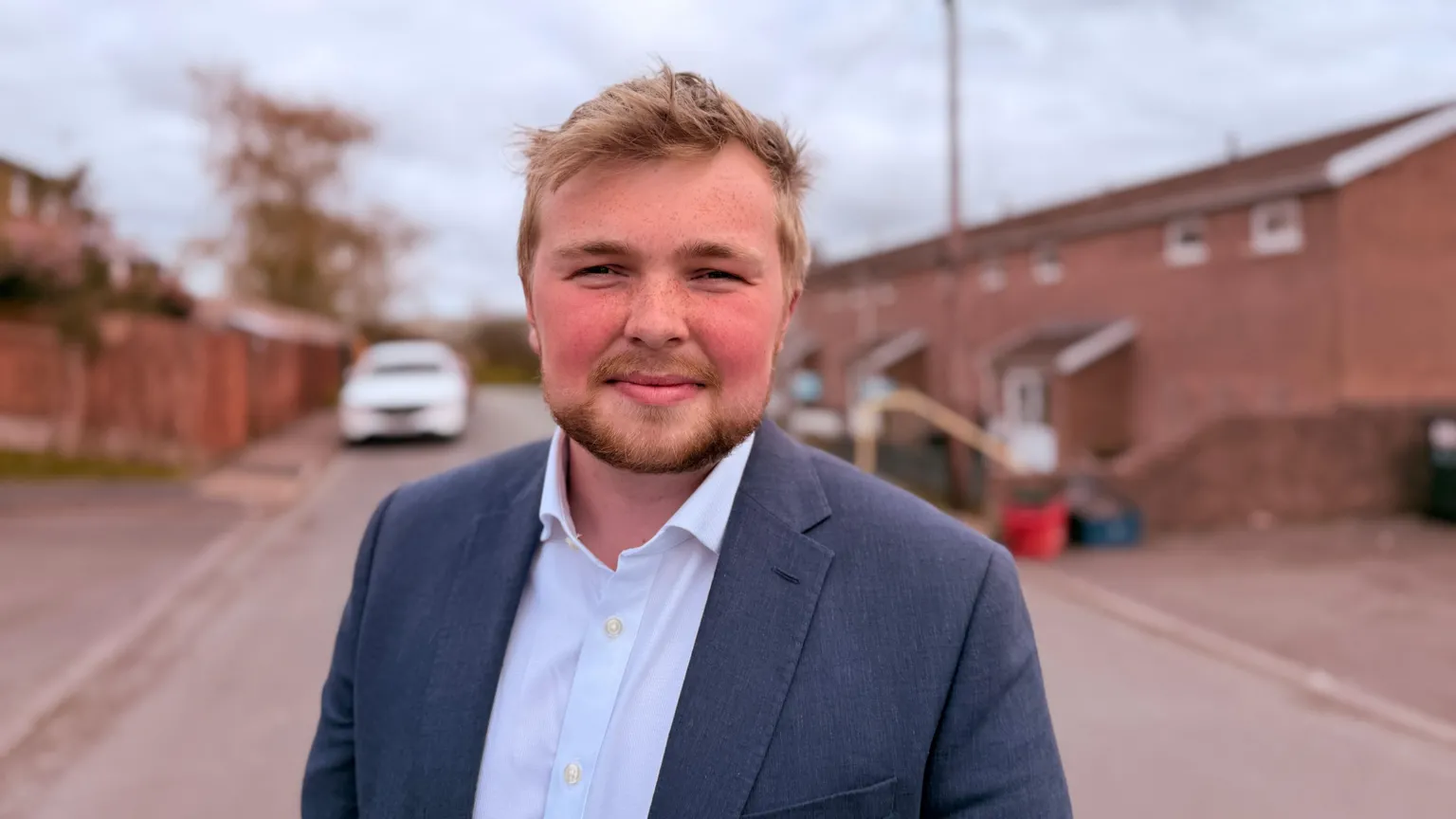 A man with blonde hair, Tyler Chambers, is smiling.