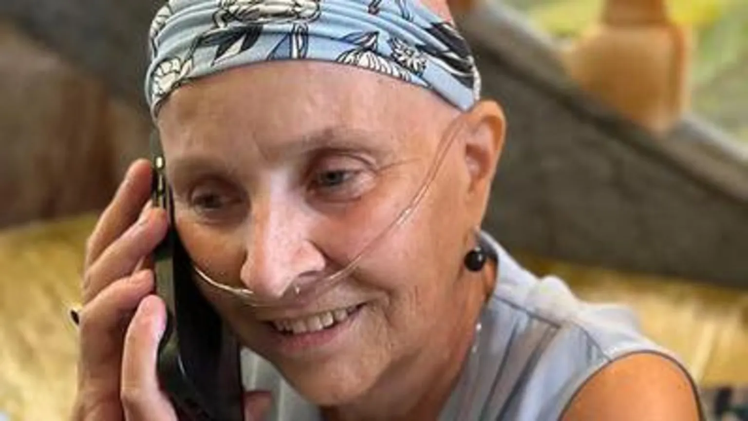 Lobular Moon Shot Project A woman wearing a blue headband holding a mobile phone up to her right ear