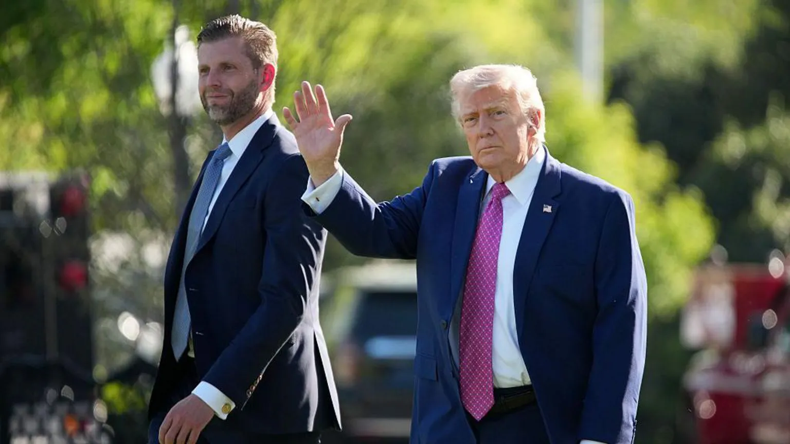 Donald Trump waves as he walks alongside his son Eric. 