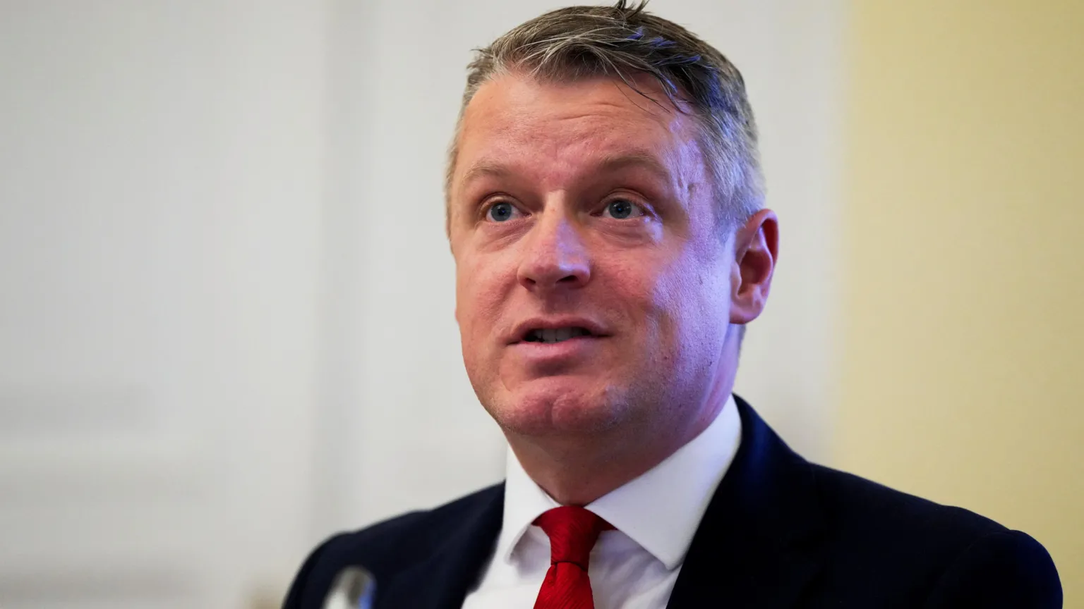  Defence Minister Luke Pollard, with short grey hair, wearing a white shirt, red tie and black suit. 