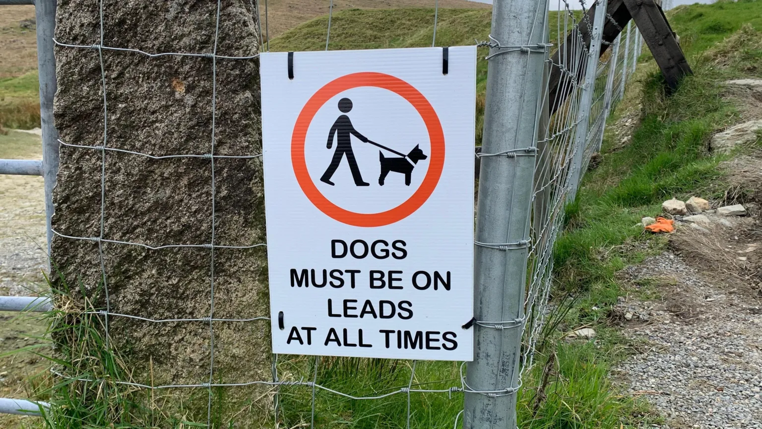 A sign attached to a fence tells people that 