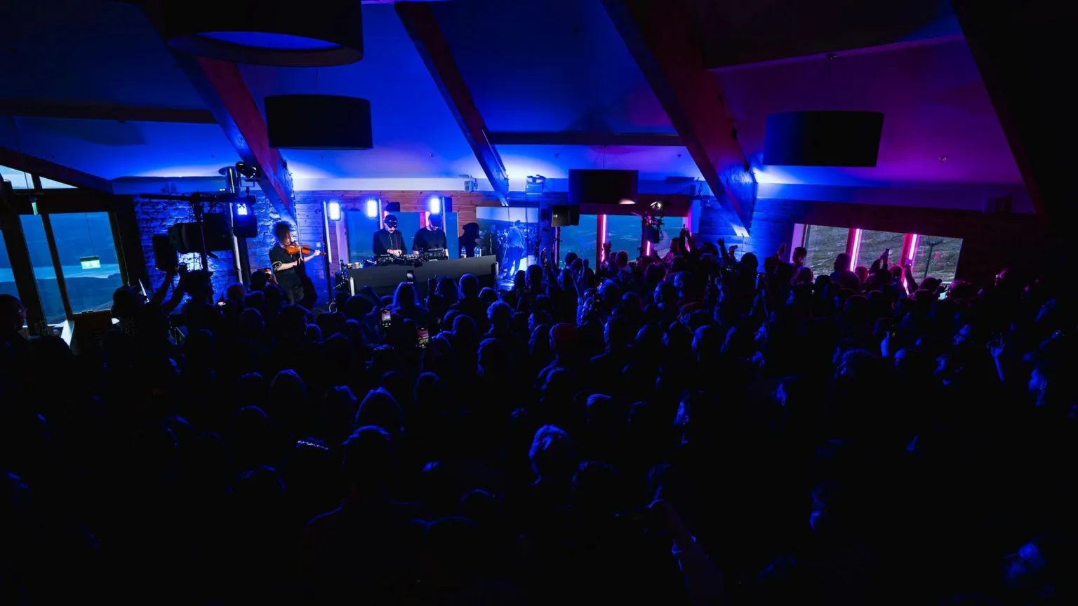 Cairngorm Mountain A crowd of people are inside the Ptarmigan Top Station, bathed in a blue light as they watch Valtos perform.