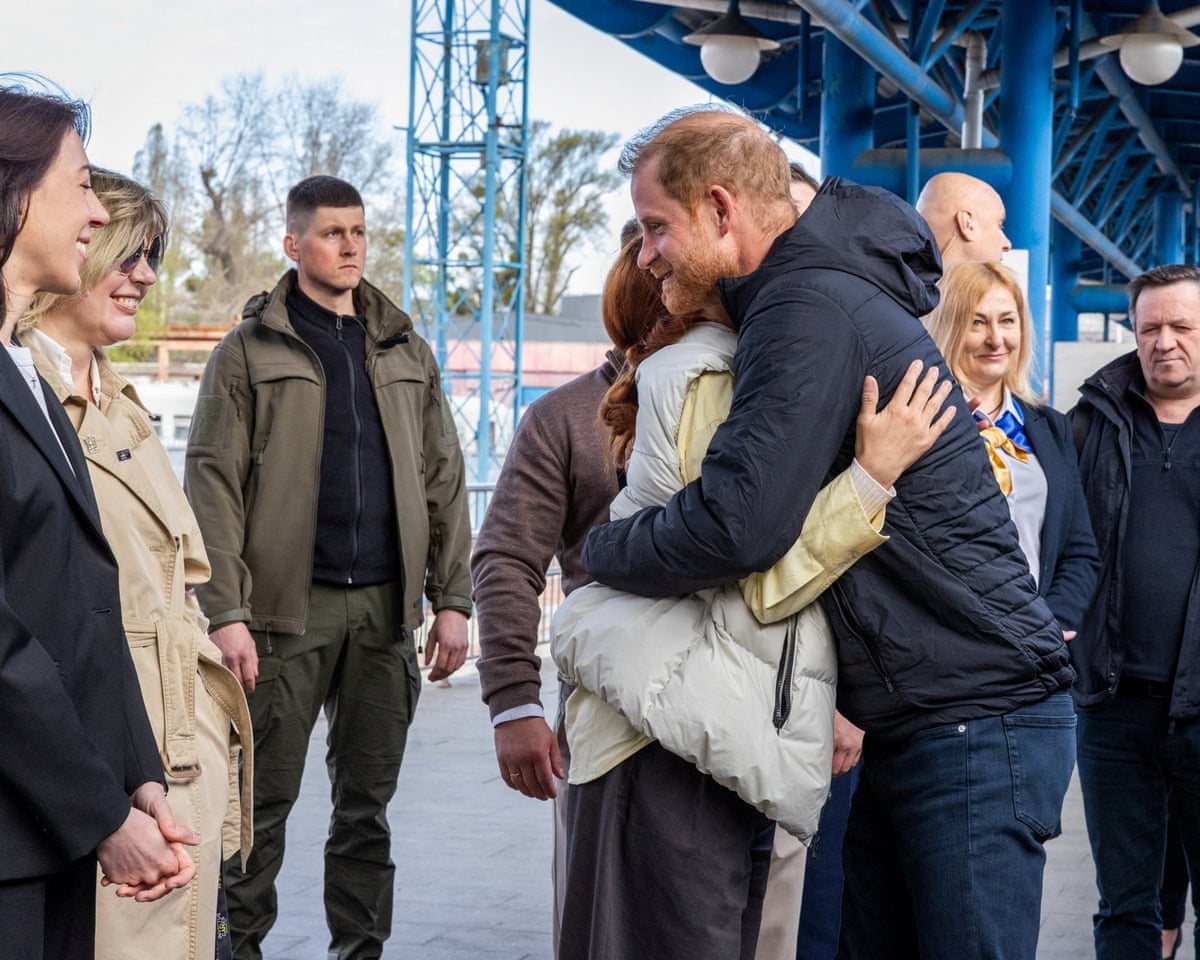 Prince Harry embraces a woman as he arrives at Kyiv railway station