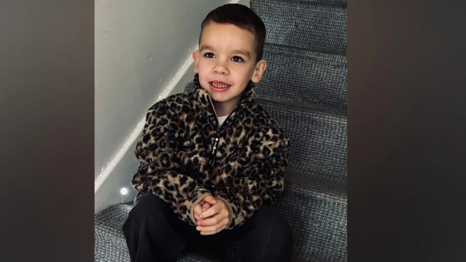 Kendra Hazlett A boy in a fleece sitting on stairs