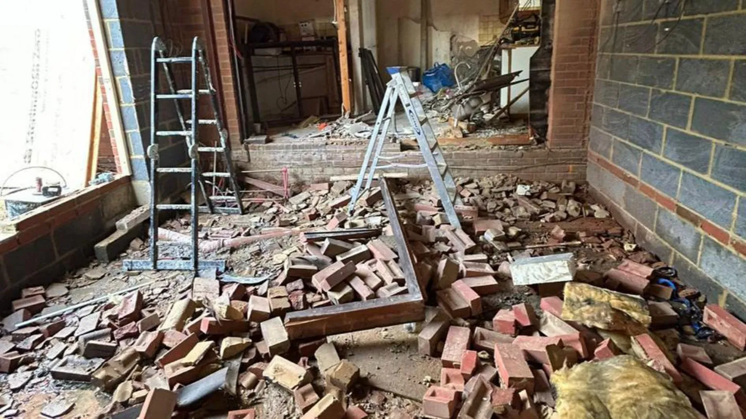 Rob Davies Two ladders among a huge pile of bricks inside a gutted property. The scene is a total mess.
