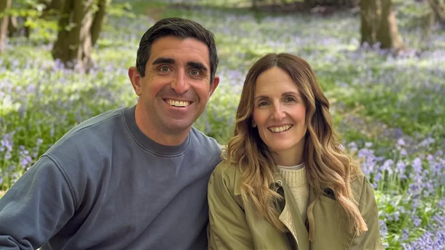 Gemma Hemmings Steve and Gemma Hemmings sitting and smiling in front of a field of bluebells. Steve has short black hair and is wearing a blue jumper. Gemma has long, curled blonde hair and is wearing a green jacket.