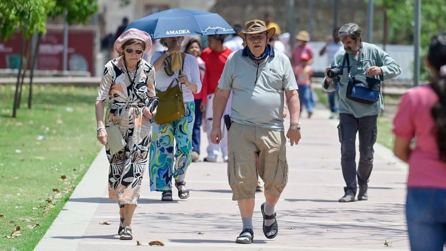  Visitors are seen protecting themselves from the sun on a hot summer day outside Humayun's Tomb on April 21, 2026 in New Delhi, India.