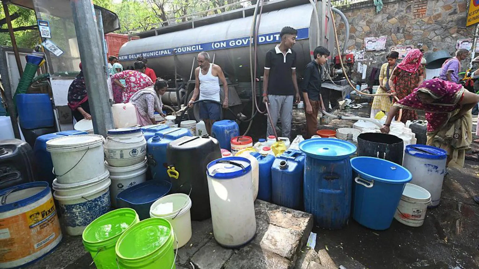  Residents of a slum cluster collect water from a municipal tanker of the Delhi Jal Board on a hot summer day as the water crisis continues at Sanjay Camp Chanakya Puri on April 21, 2026 in New Delhi, India.