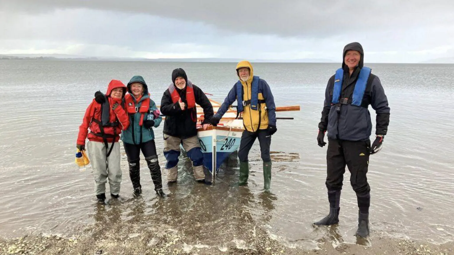 Wigtown Coastal Rowing Club A group of people stand around a boat