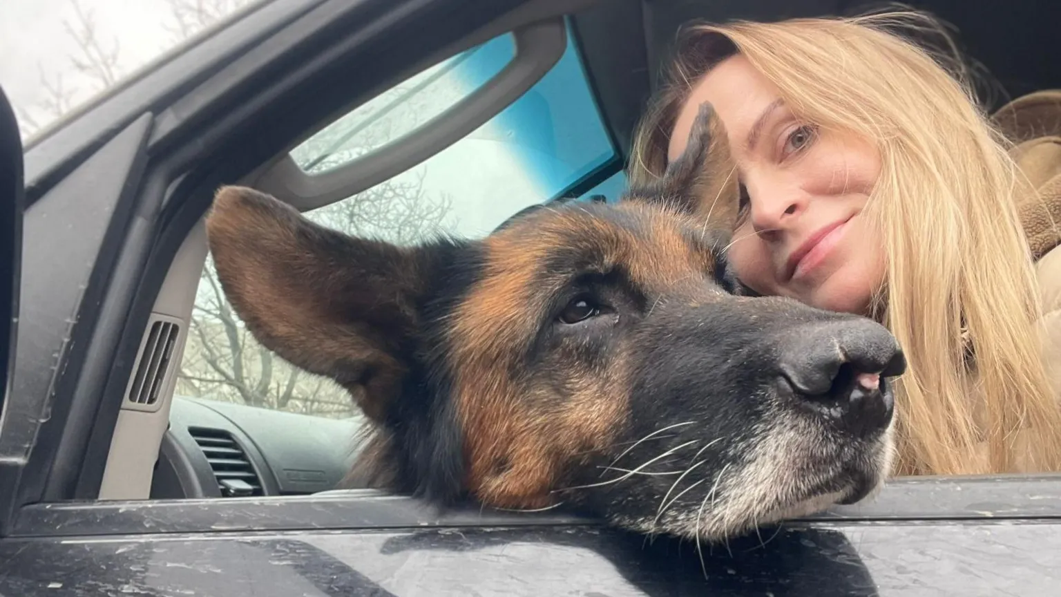 Lala Tarapakina/12 s A woman with blonde hair with a dog in a car