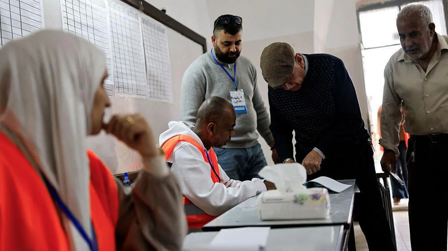  Voters taking and election officials speaking at a polling station in Jenin