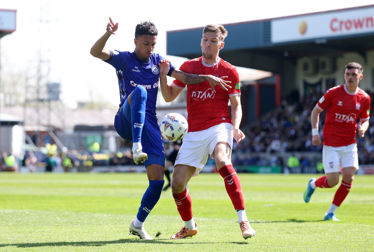 Rochdale’s Kyron Gordon (left) is challenged by York’s Mark Kitching at the Crown Oil Arena.