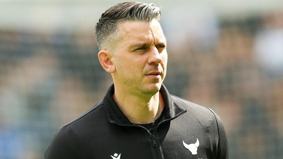 Matt Bloomfield, wearing a black top with a white Oxford logo of an ox's head, looks dejected following the defeat at Derby on 18 April