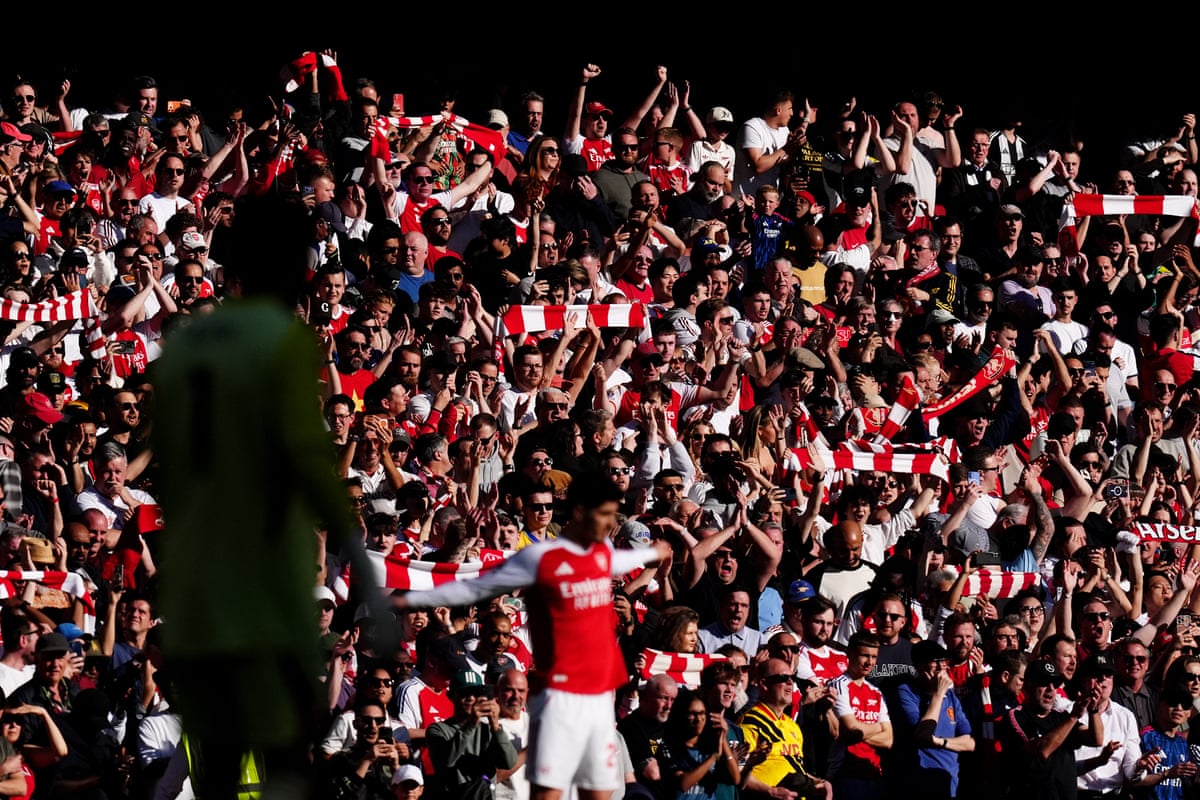 Arsenal fans cheer their team as kick-off approaches.