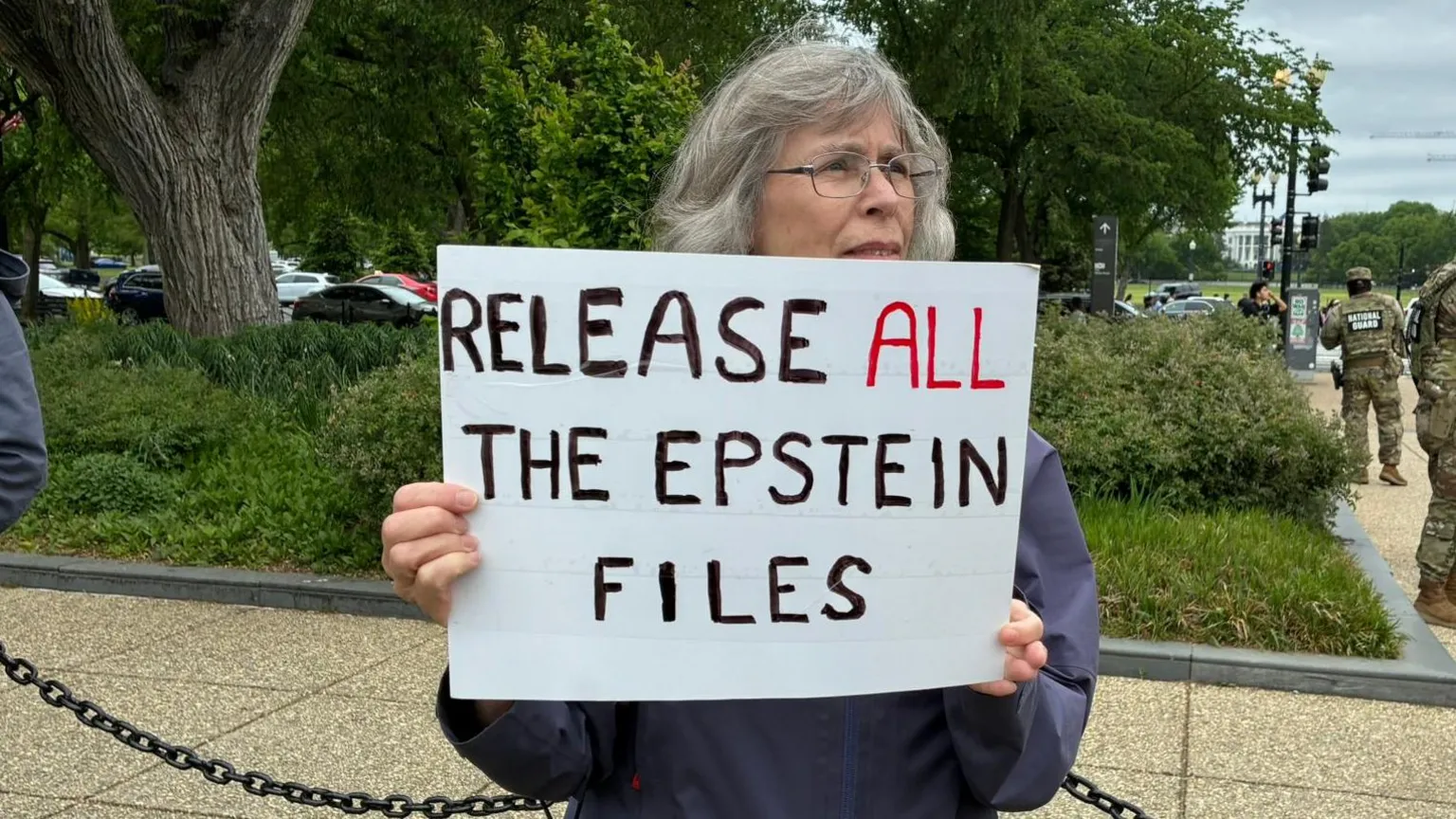 A protester holds up a sign saying 'Release all the Epstein files'