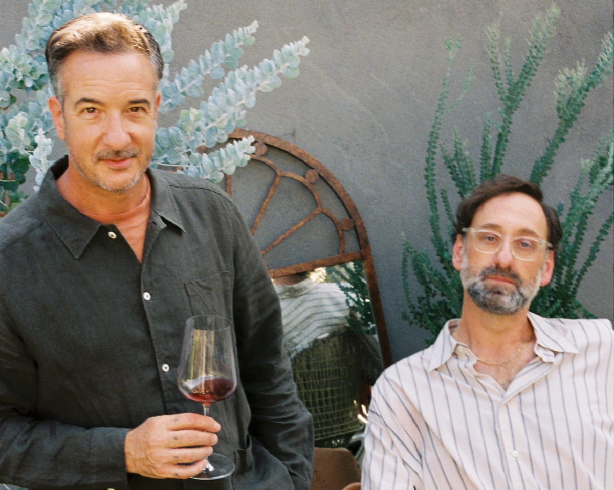 Two middle-aged men drinking wine