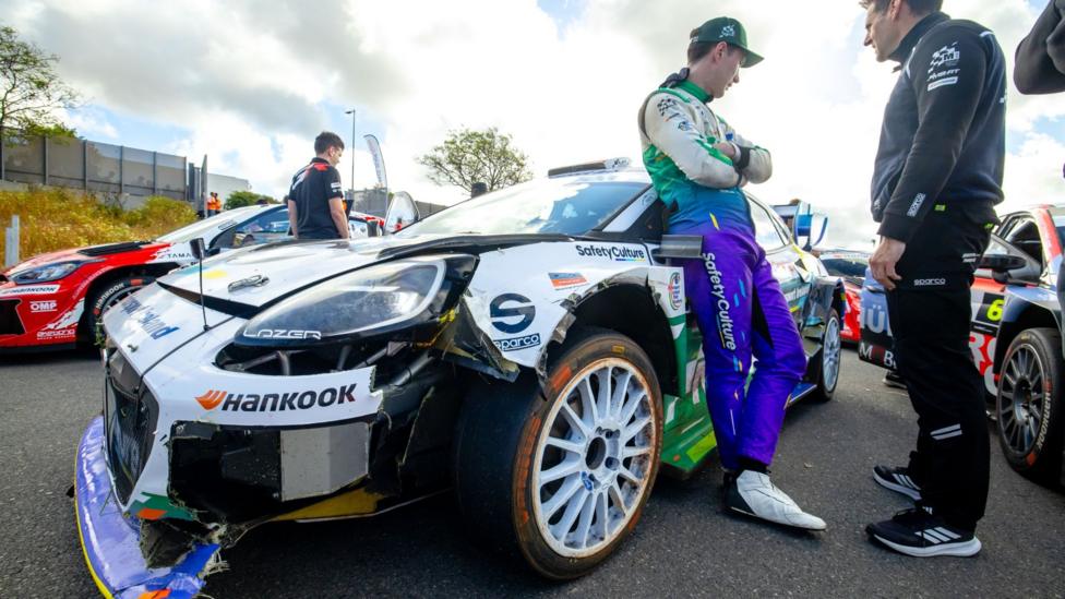 Jon Armstrong of Ireland leans on his damaged M-Sport Ford Puma during service at Rally Islas Canarias