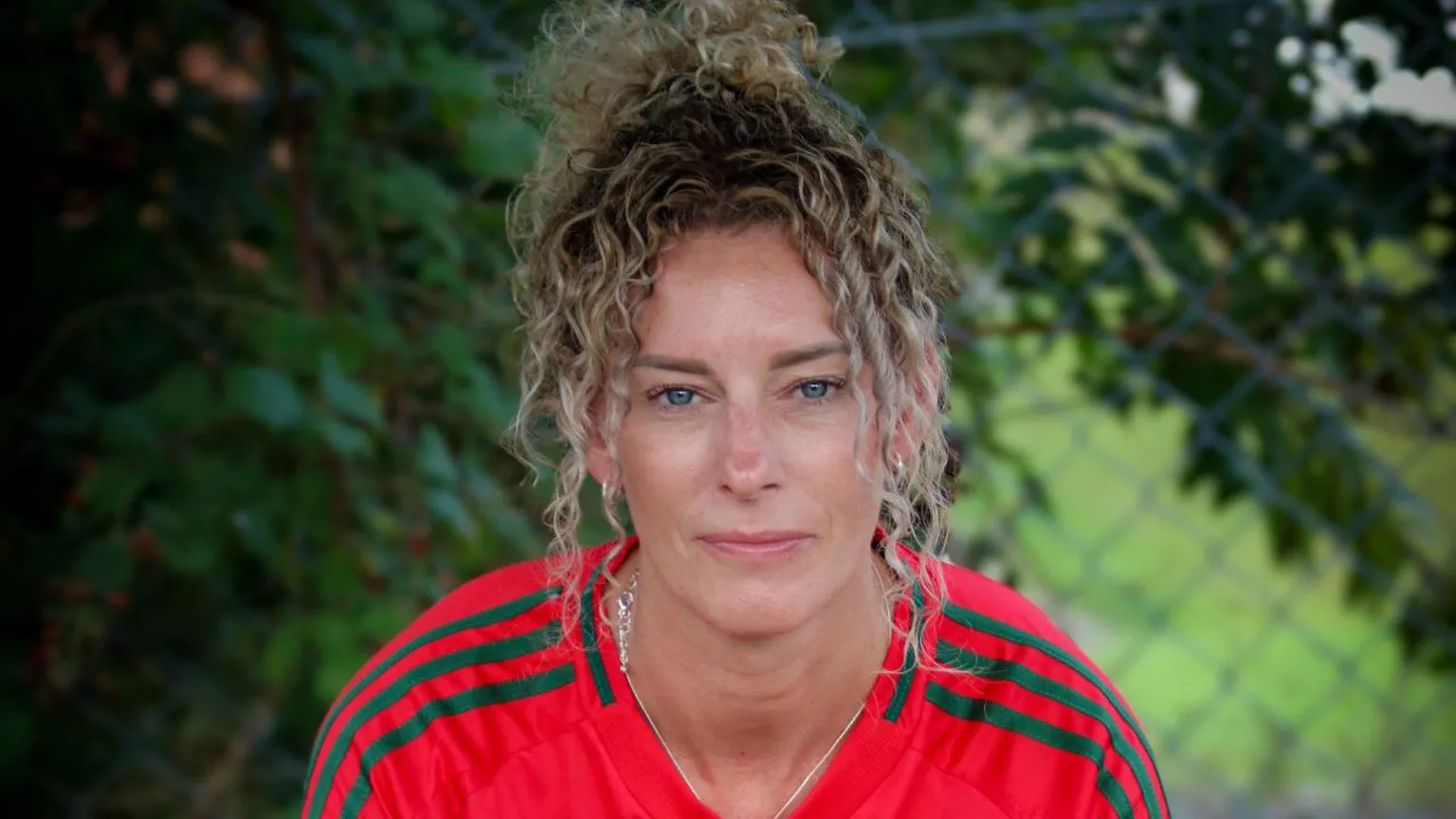 The Homeless World / Street Football Wales Headshot of a middle aged woman wearing a red Wales football jersey