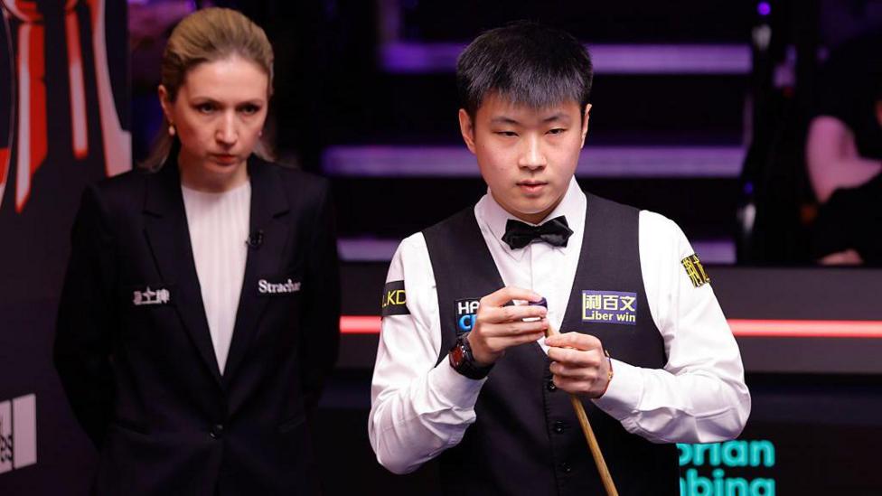Zhao Xintong chalks his cue