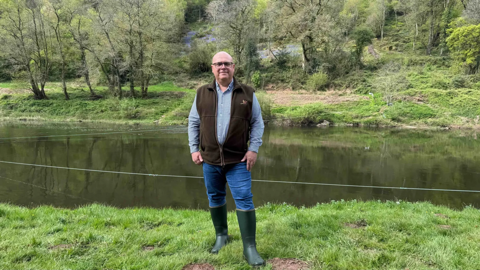 Nicola Goodwin/ A fisherman stands on the banks of the River Wye