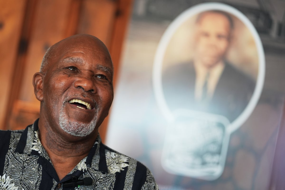 Edward Threatt in front of a photograph of his grandfather Allen Threatt Sr