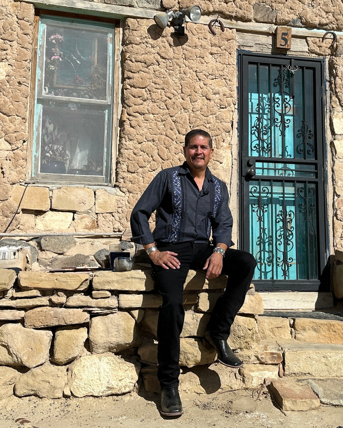 Max Early sitting outside a stone house