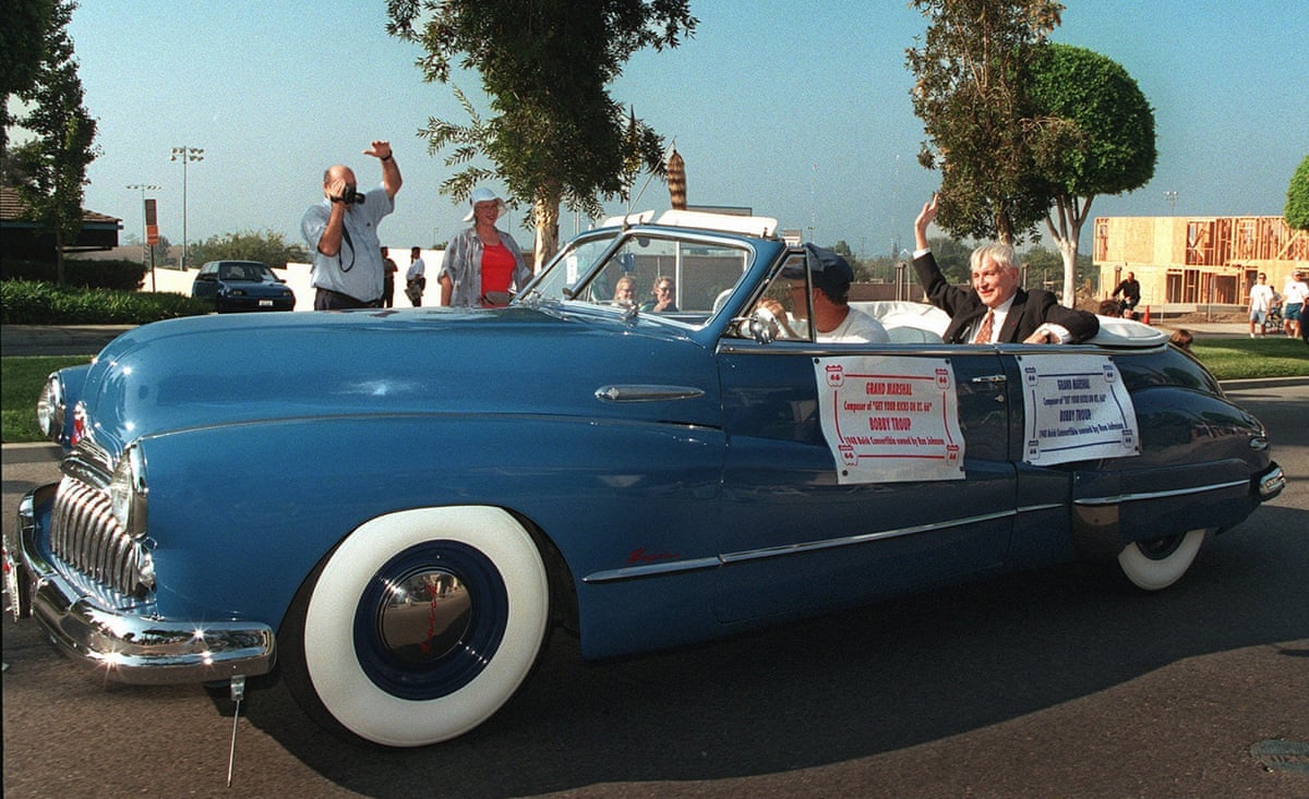 Bobby Troup in the back of a Buick convertible waving to fans