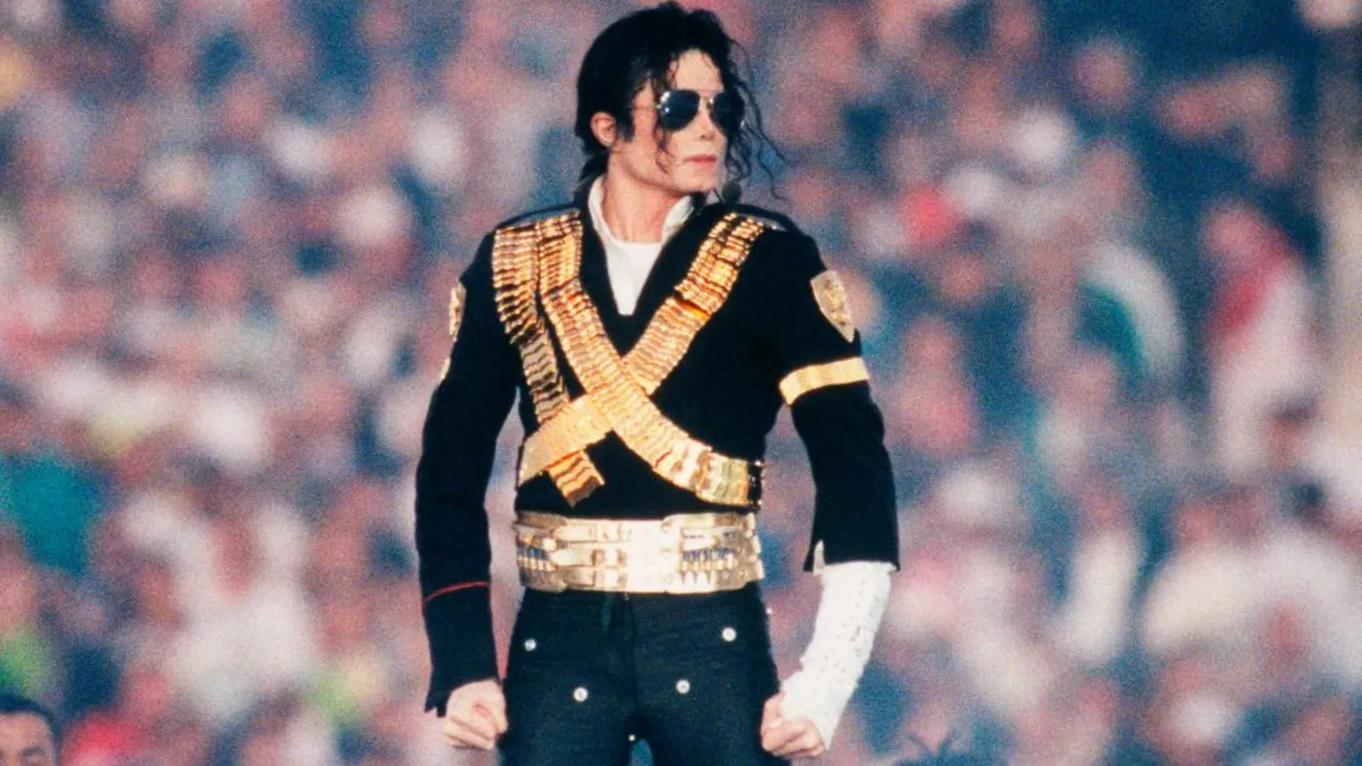  Singer Michael Jackson, wearing a black and gold suit, performs at the 1993 Pasadena, California, Superbowl XXVII halftime show. 