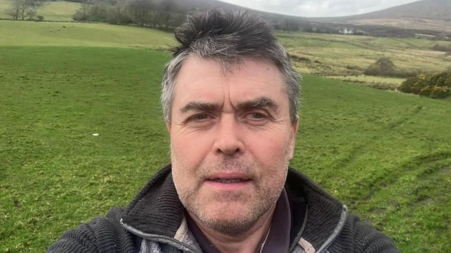 Thomas Conway Shows a man with grey hair and a dark 